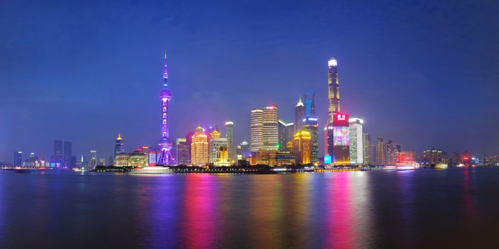 Shanghai city skyline Pudong side looking through Huangpu river on twilight time. Shanghai, China. Beutiful vibrant panoramic image.