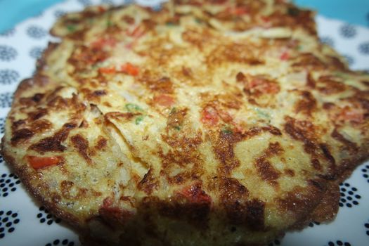 Close-up view with selective focus of egg omelet with peppers and spices sprinkled