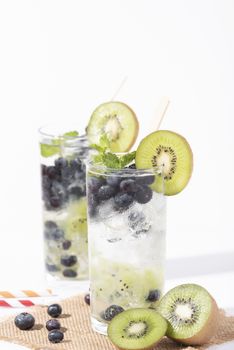 Kiwi cocktails beverage with ripe blueberry on white background. summer drink.