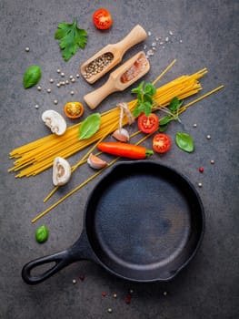 Italian food and menu concept. Spaghetti with ingredients sweet basil ,tomato ,garlic peppercorn and champignon on dark background flat lay and copy space.