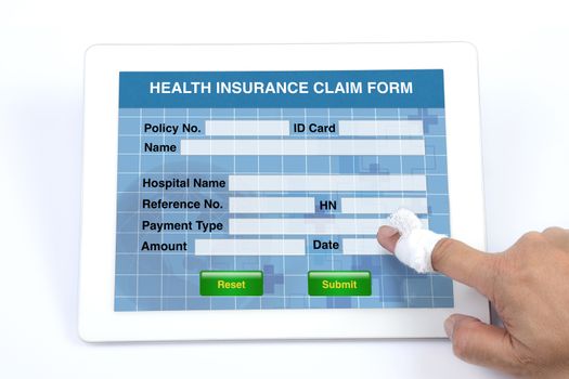Someone using tablet to complete health insurance claim form on white background.