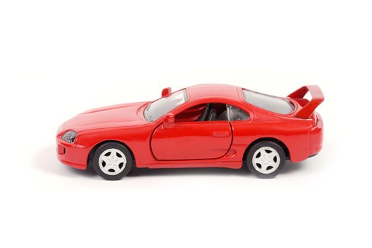 Red toy model sport car on white background.