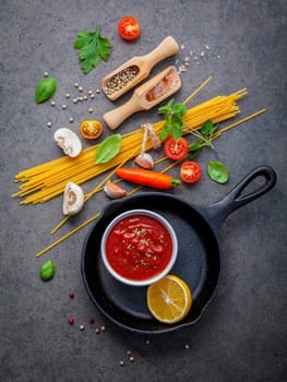 Italian food and menu concept. Spaghetti with ingredients sweet basil ,tomato ,garlic peppercorn and champignon on dark background flat lay and copy space.