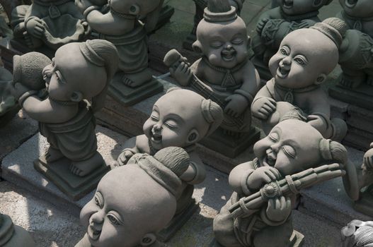 Various style of sandstone child statue in thailand culture for garden decoration.