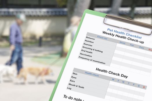 Pet health checklist on clipboard with blur background of people take dog to walks and exercise.