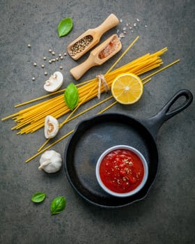 Italian food and menu concept. Spaghetti with ingredients sweet basil ,tomato ,garlic peppercorn and champignon on dark background flat lay and copy space.