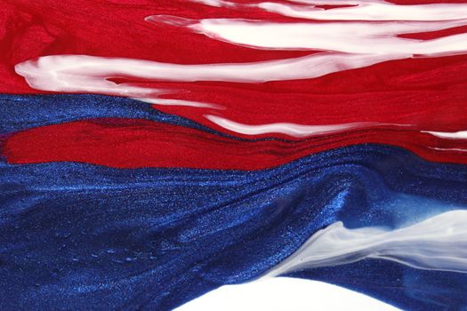 Red, White and Blue Nail Polish Spilled on White Background