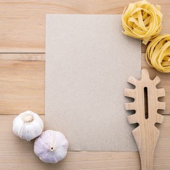 Italian foods concept and menu design . Blank paper and  pasta ladle on wooden background.