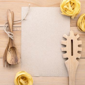 Italian foods concept and menu design . Blank paper and  pasta ladle on wooden background.