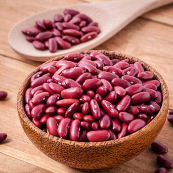 Close Up red kidney beans in wooden bowl on wooden background. 
