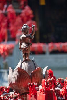 Buddha statue standing on a lotus flower with red stripes in LuoHanCi temple Chongqing, China