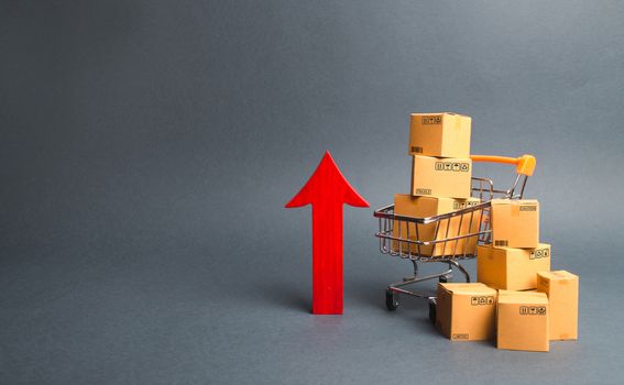Shopping cart with cardboard boxes and red up arrow. Growth wholesale and retail. Improving consumer sentiment, economic growth. Rising prices for goods, inflation. growth of popularity of the product