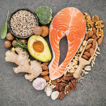 Heart shape of ketogenic low carbs diet concept. Ingredients for healthy foods selection on dark stone background. Balanced healthy ingredients of unsaturated fats for the heart and blood vessels.