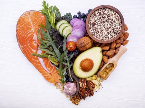 Heart shape of ketogenic low carbs diet concept. Ingredients for healthy foods selection on white wooden background. Balanced healthy ingredients of unsaturated fats for the heart and blood vessels.