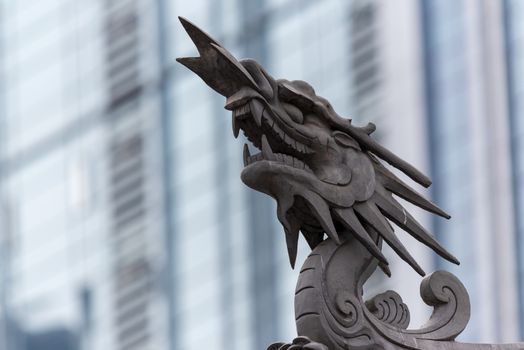 Dragon sculpture on Daci buddhist temple roof against modern building in Chengdu, China