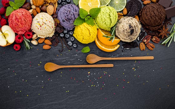 Various of ice cream flavor ball blueberry ,lime ,pistachio ,almond ,orange ,chocolate and vanilla set up on dark stone background . Summer and Sweet menu concept.