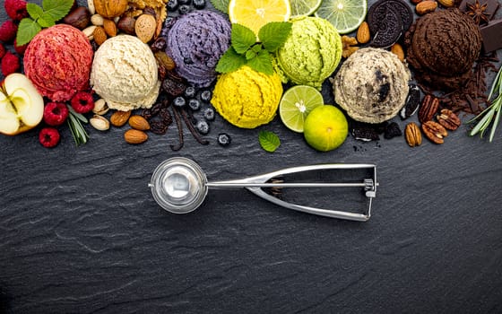 Various of ice cream flavor ball blueberry ,lime ,pistachio ,almond ,orange ,chocolate and vanilla set up on dark stone background . Summer and Sweet menu concept.