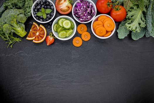 Colourful ingredients for healthy smoothies and juices on dark stone background with copy space.