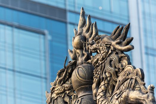 Dragon sculpture on Daci buddhist temple roof against modern building in Chengdu, China