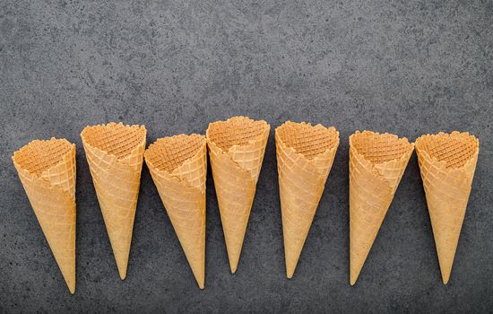 Flat lay ice cream cones collection on dark stone background . Blank crispy ice cream cone with copy space for sweets menu design.