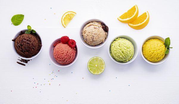 Various of ice cream flavor ball blueberry ,lime ,pistachio ,almond ,orange ,chocolate and vanilla set up on white wooden background . Summer and Sweet menu concept.