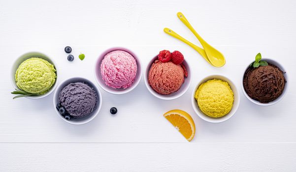 Various of ice cream flavor ball blueberry ,lime ,pistachio ,almond ,orange ,chocolate and vanilla set up on white wooden background . Summer and Sweet menu concept.