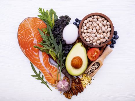 Heart shape of ketogenic low carbs diet concept. Ingredients for healthy foods selection on white wooden background. Balanced healthy ingredients of unsaturated fats for the heart and blood vessels.