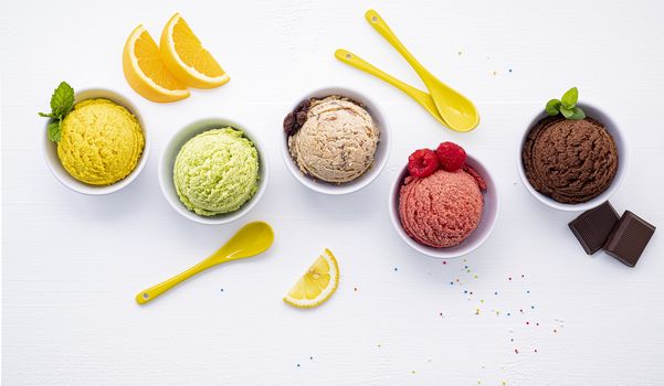 Various of ice cream flavor ball blueberry ,lime ,pistachio ,almond ,orange ,chocolate and vanilla set up on white wooden background . Summer and Sweet menu concept.