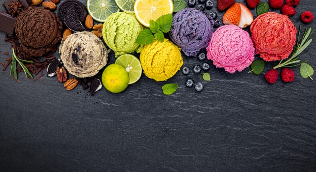 Various of ice cream flavor ball blueberry ,lime ,pistachio ,almond ,orange ,chocolate and vanilla set up on dark stone background . Summer and Sweet menu concept.