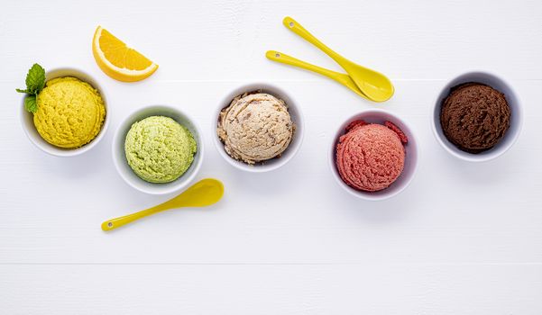 Various of ice cream flavor ball blueberry ,lime ,pistachio ,almond ,orange ,chocolate and vanilla set up on white wooden background . Summer and Sweet menu concept.