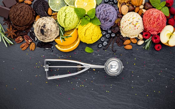 Various of ice cream flavor ball blueberry ,lime ,pistachio ,almond ,orange ,chocolate and vanilla set up on dark stone background . Summer and Sweet menu concept.