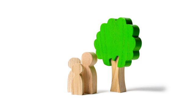 Family figures are standing near the tree on an isolated background. Pastime with family, kinship and parenting. Instilling good qualities and values in a healthy society. The concept of happiness