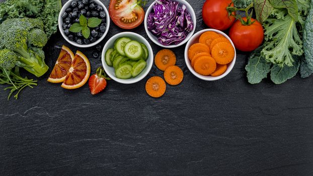 Colourful ingredients for healthy smoothies and juices on dark stone background with copy space.