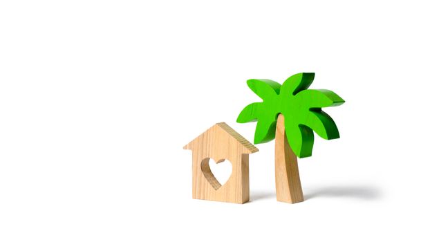 Wooden palm tree and house with hearts on an isolated background. Conceptual leisure and vacation. Rental homes and properties in the resort. Romantic travel. Entertainment and relaxation.