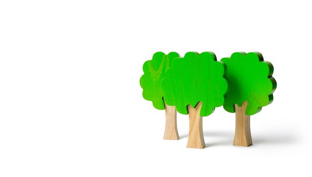 Three toy wooden figures of trees on an isolated background. Forest imitation. environmental conservation. Light planets. Family tree, a symbol of strength and wisdom. Illegal deforestation.