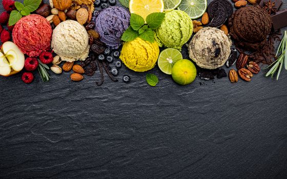 Various of ice cream flavor ball blueberry ,lime ,pistachio ,almond ,orange ,chocolate and vanilla set up on dark stone background . Summer and Sweet menu concept.