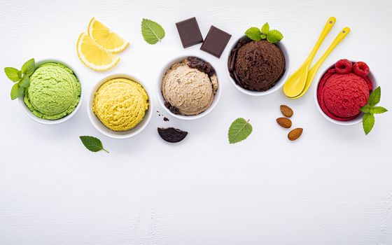 Various of ice cream flavor ball blueberry ,lime ,pistachio ,almond ,orange ,chocolate and vanilla set up on white wooden background . Summer and Sweet menu concept.