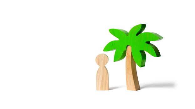 The figure of the person costs under a wooden palm treeon an isolated background. Vacation or trip. Stuck on a desert island. Personal space and moral rest. balance in life, psychological health
