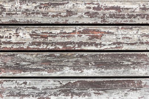 The old wooden planks of a barn with peeling paint