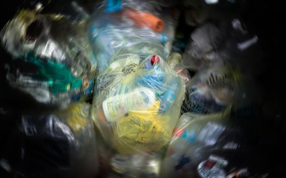 Close Up of garbage and waste in transparent bags. Radial blur effect.