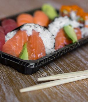 Closeup of fresh sushi on rustic wooden table. Shallow depth of field.