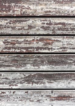 The old wooden planks of a barn with peeling paint
