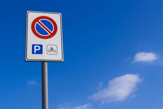 Do not park signage, motorcycle parking only. Background blue sky for copy space.