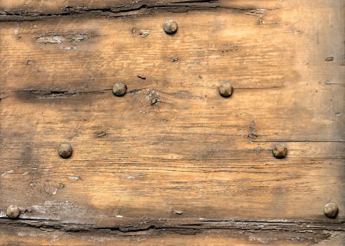 Detail of a medieval wooden door with large rusted nails