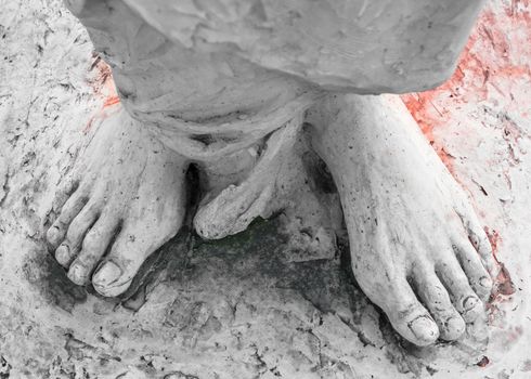 Extreme close-up of the feet of Jesus Christ bloodied. Top view. Shallow depth of field.