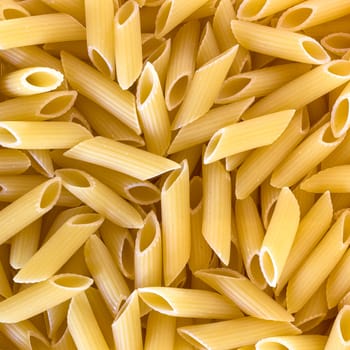 Close-up of raw penne pasta, texture or background, italian design