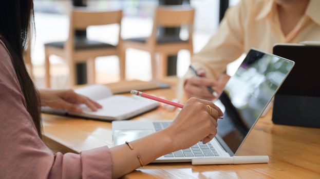 Close-up shot of Two male and female professionals are planning to present a new project in the future. With a laptop and desk accessories.