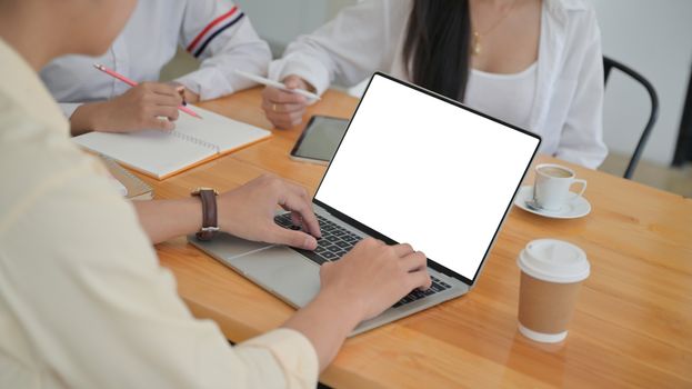 Cropped shot of A group of young professionals are searching for information from laptop and taking notes for management proposals for future projects.