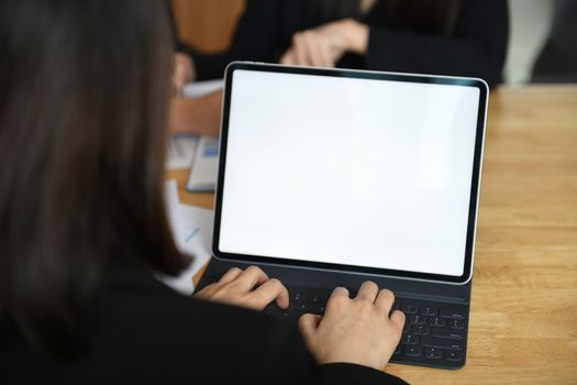Cropped shot of a female employee typing a keyboard on a laptop with a blank white screen.