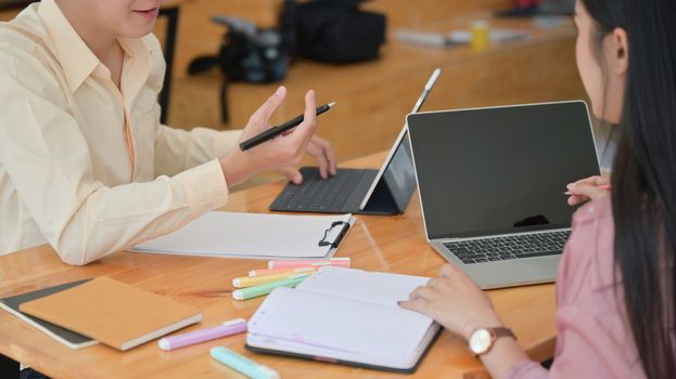 Cropped shot of Two male and female professionals are planning to present a new project in the future. With a laptop and desk accessories.